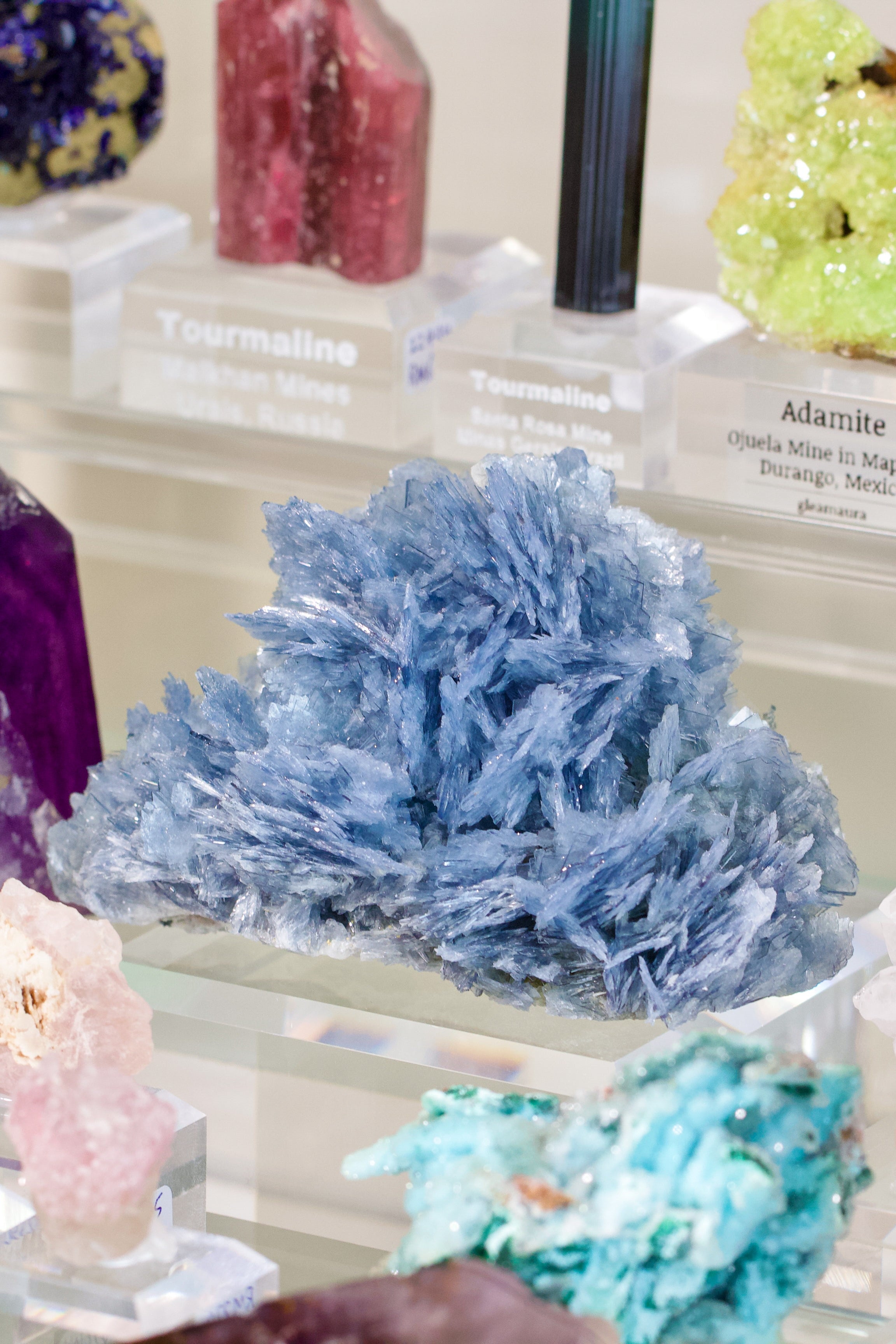 Collection of various colorful crystals and minerals on a display stand.